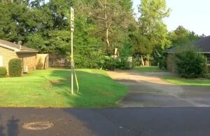 Detienen a tercer menor por homicidio en Tuscaloosa Cinta de precaución amarilla amarrada a una señal de tránsito frente a casas residenciales en Alabama.