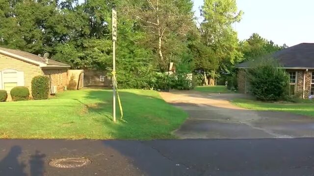 Detienen a tercer menor por homicidio en Tuscaloosa Cinta de precaución amarilla amarrada a una señal de tránsito frente a casas residenciales en Alabama.