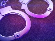 Arrestos en Alabama por red de contrabando en prisiones Esposas de metal iluminadas con luz violeta representativas del arresto por contrabando en prisiones.