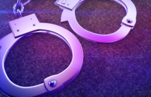 Arrestos en Alabama por red de contrabando en prisiones Esposas de metal iluminadas con luz violeta representativas del arresto por contrabando en prisiones.