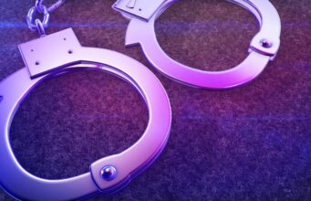 Arrestos en Alabama por red de contrabando en prisiones Esposas de metal iluminadas con luz violeta representativas del arresto por contrabando en prisiones.