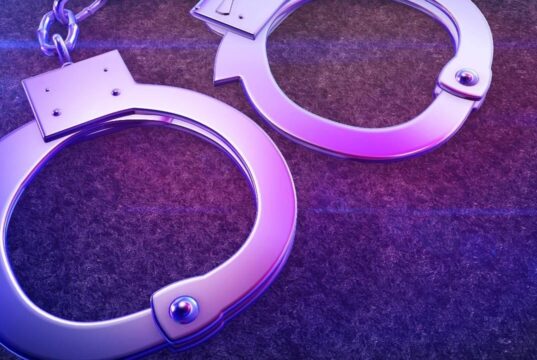 Arrestos en Alabama por red de contrabando en prisiones Esposas de metal iluminadas con luz violeta representativas del arresto por contrabando en prisiones.