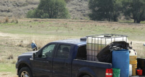 FGR desarticula centros ilícitos de combustible en México Camioneta Ford en zona rural cargada con tanque IBC de combustible y tambos asegurados por la FGR.
