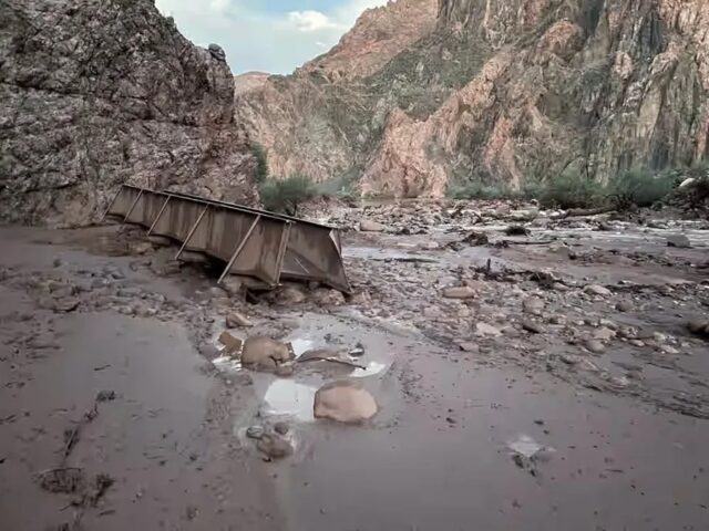 Pasarela metálica arrastrada y terreno cubierto de lodo tras inundación repentina en el Gran Cañón.