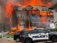 Incendio en apartamentos de Birmingham deja 20 desplazados Voraz incendio consume edificio de apartamentos en Birmingham con patrulla policial en primer plano.