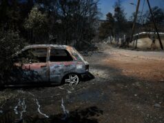 Incendio en Grecia fuera de control devora 12.600 hectáreas Coche calcinado junto a árboles quemados tras un grave incendio en Grecia.