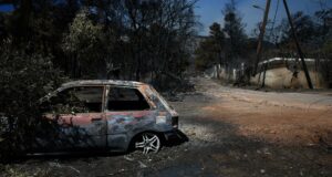 Incendio en Grecia fuera de control devora 12.600 hectáreas Coche calcinado junto a árboles quemados tras un grave incendio en Grecia.