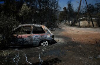 Incendio en Grecia fuera de control devora 12.600 hectáreas Coche calcinado junto a árboles quemados tras un grave incendio en Grecia.