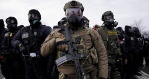 ICE pagará un seguro para policías locales en inmigración Agentes federales y policías armados con equipamiento táctico durante operativos de inmigración en Estados Unidos.