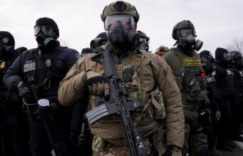 ICE pagará un seguro para policías locales en inmigración Agentes federales y policías armados con equipamiento táctico durante operativos de inmigración en Estados Unidos.