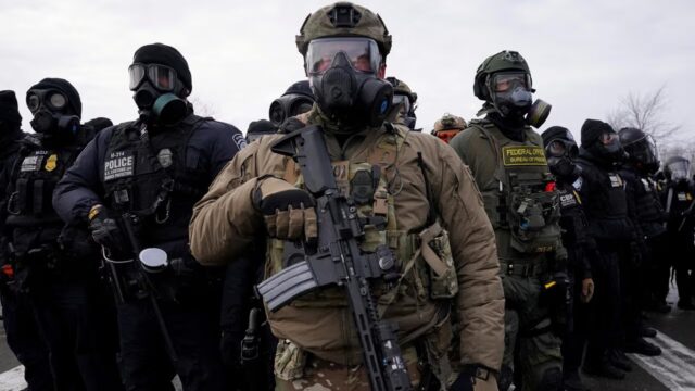 ICE pagará un seguro para policías locales en inmigración Agentes federales y policías armados con equipamiento táctico durante operativos de inmigración en Estados Unidos.