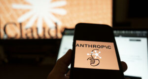 Inteligencia artificial muestra conductas autónomas y engañosas Mano sosteniendo un teléfono con el logo de Anthropic frente a una pantalla con el nombre de Claude.
