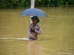 Monzón en India deja 115 muertos y miles de evacuados Hombre caminando con el agua a la cintura sosteniendo una sombrilla durante las inundaciones por el monzón en India.