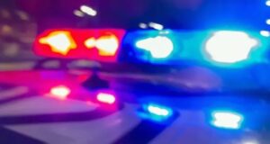 Demanda a la policía de Madison por fatal choque vial Luces de emergencia rojas y azules de una patrulla policial desenfocadas durante la noche.