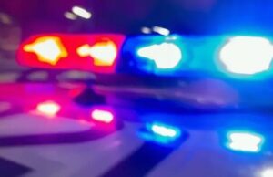 Demanda a la policía de Madison por fatal choque vial Luces de emergencia rojas y azules de una patrulla policial desenfocadas durante la noche.
