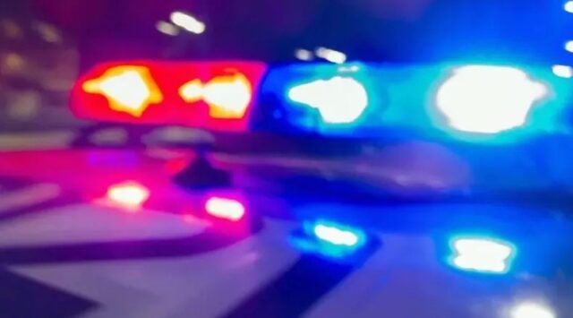 Luces de emergencia rojas y azules de una patrulla policial desenfocadas durante la noche.