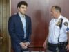 Luigi Mangione se declara culpable por crimen de Brian Thompson Luigi Mangione en traje formal y esposado junto a un oficial dentro de un tribunal de Nueva York.