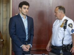 Luigi Mangione se declara culpable por crimen de Brian Thompson Luigi Mangione en traje formal y esposado junto a un oficial dentro de un tribunal de Nueva York.