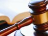 Condenan a banda por tráfico de metanfetamina en Alabama Mazo de madera de juez reposando sobre una mesa junto a un libro de leyes en un tribunal.