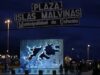 Buque británico en Ushuaia genera tensión con Milei Letrero nocturno de la Plaza Islas Malvinas en la Municipalidad de Ushuaia con un monumento iluminado al fondo.