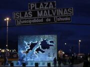 Buque británico en Ushuaia genera tensión con Milei Letrero nocturno de la Plaza Islas Malvinas en la Municipalidad de Ushuaia con un monumento iluminado al fondo.