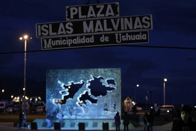 Buque británico en Ushuaia genera tensión con Milei Letrero nocturno de la Plaza Islas Malvinas en la Municipalidad de Ushuaia con un monumento iluminado al fondo.