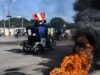 Subsidio a combustibles en Perú aliviará a transportistas Mototaxis con banderas de Perú protestan en una calle bloqueada con neumáticos en llamas.