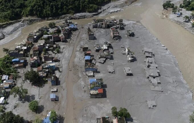 Riada en Nepal deja cientos de desaparecidos y municipios aislados Vista aérea de la riada en Nepal con edificaciones sepultadas por el lodo y ríos desbordados.