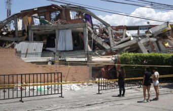 Terremoto en Colombia deja 281 muertos y 379 desaparecidos Personas observando la estructura colapsada de un edificio destruido por el terremoto en Colombia.