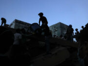 Terremoto en Colombia de 7,4 deja 132 muertos y desastre Rescatistas y voluntarios remueven escombros tras el terremoto en Colombia durante el atardecer.