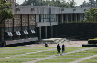 Examen UNAM 2026 presencial tras uso de inteligencia artificial Estudiantes caminando por las instalaciones del campus de la UNAM en México tras anuncio de examen presencial.