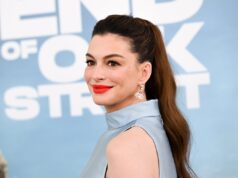 Anne Hathaway sufre ataques conservadores en redes sociales Retrato de la actriz Anne Hathaway en una alfombra roja luciendo peinado de cola de caballo y labial rojo.