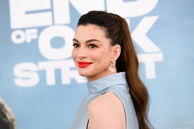 Anne Hathaway sufre ataques conservadores en redes sociales Retrato de la actriz Anne Hathaway en una alfombra roja luciendo peinado de cola de caballo y labial rojo.