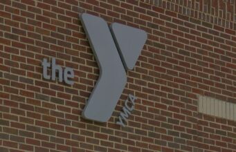 Coosa Valley YMCA anuncia el cierre definitivo de sus sedes Logotipo de la YMCA sobre una pared de ladrillos rojos en la sede corporativa de la organización en Alabama.