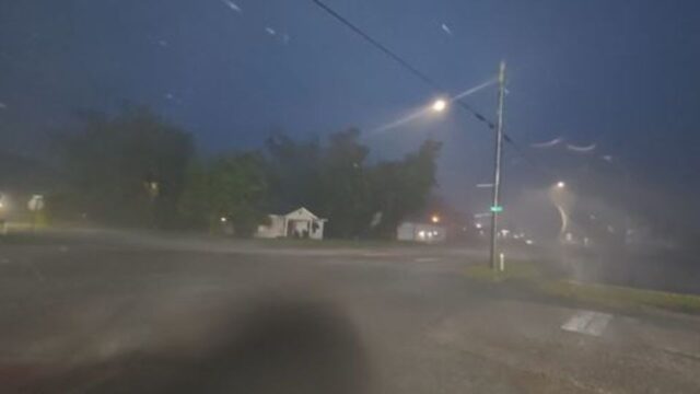 Tormenta nocturna provocada por la depresión tropical Edouard azotando una calle con lluvia y viento en Texas.