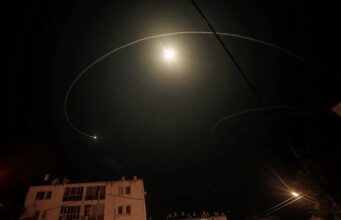 Israel intercepta dron sospechoso lanzado desde Líbano Estelas de luz en el cielo nocturno sobre edificios urbanos durante una intercepción aérea en Israel.